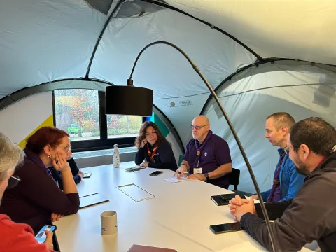 A group of adults discuss around a table.