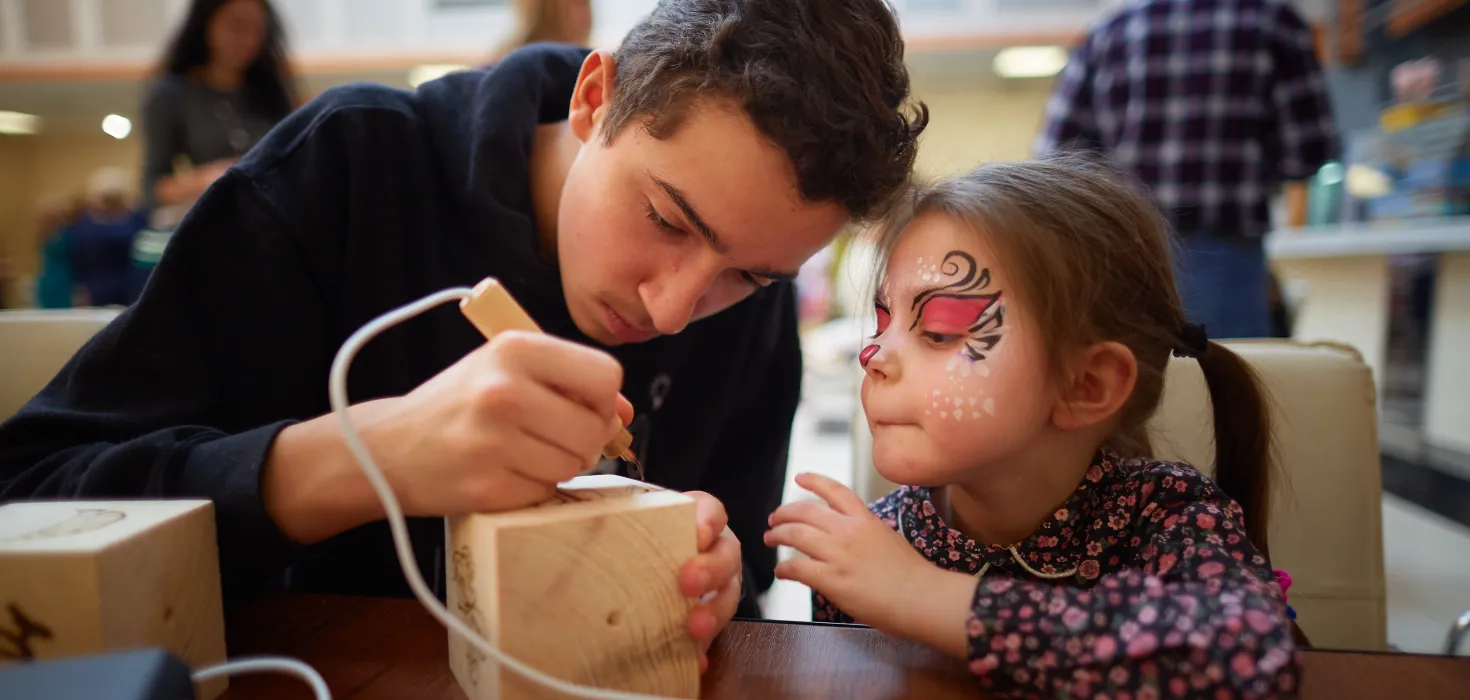 a youth doing an art activity with a child