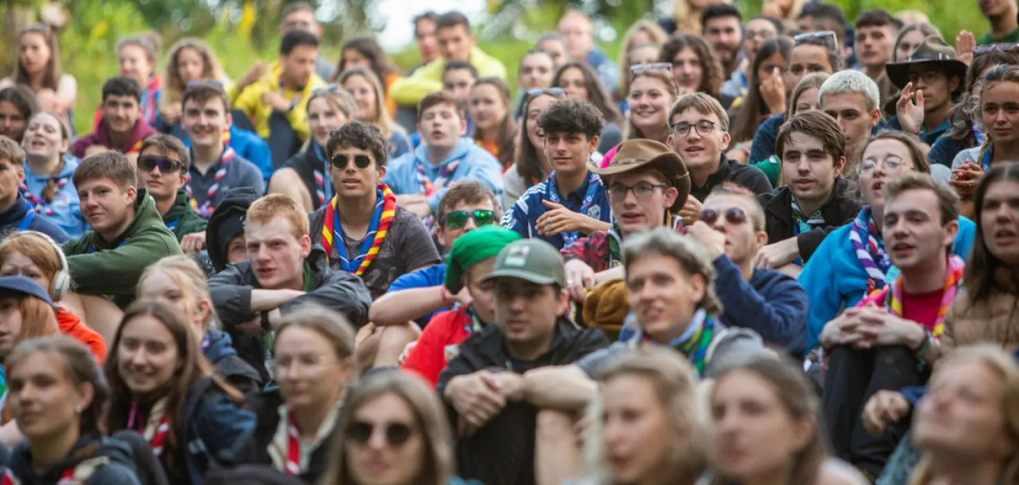 A group of young people from around the world sit on the floor.