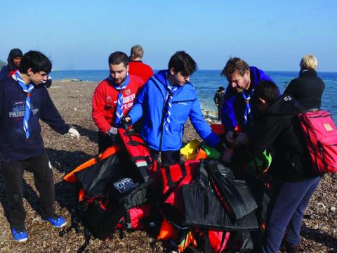 scouts collecting life jackets from the sea shore of greece