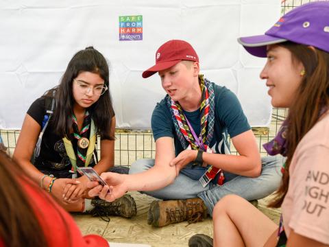 3 Scouts sit and discuss Safe From Harm at the World Scout Jamboree in West Virginia