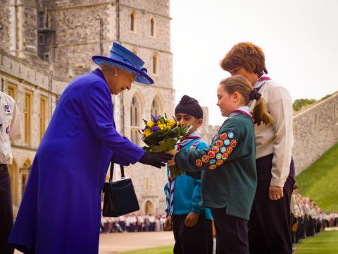 La reine Elizabeth reçoit un bouquet de fleurs de jeunes Scouts