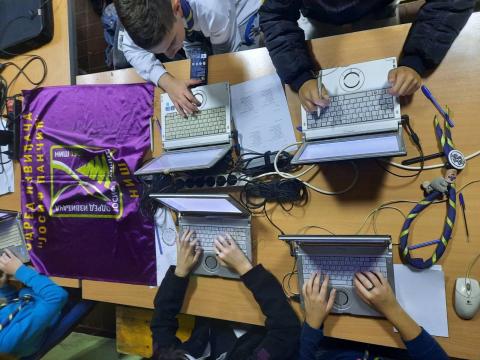 Scouts in Serbia type on laptops on a table during JOTA-JOTI