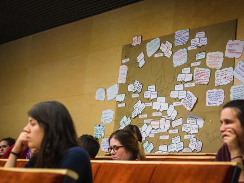 Scouts attending session of the forum with a map of Europe in the background 