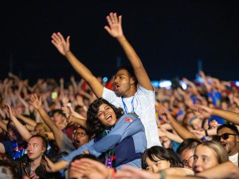 Two Scouts stand out from a huge crowd of Scouts, waving their arms in the air