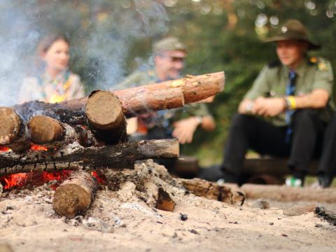 Four Scouts talk around a campfire.