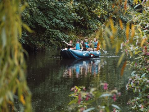 Scouts paddle on a river.