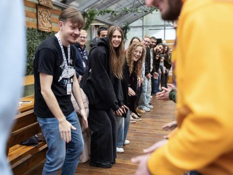 Young people stand in line making the same movements.