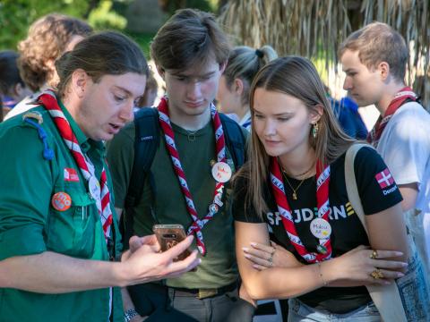 Participants from Denmark and Switzerland checking content on a phone.