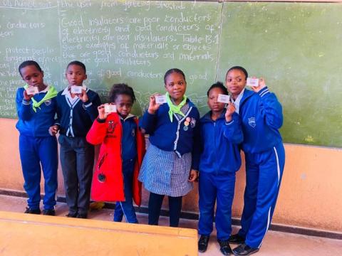 Young Scouts hold up cards