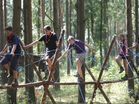 Scouts crossing a bridge in the middle of the forest