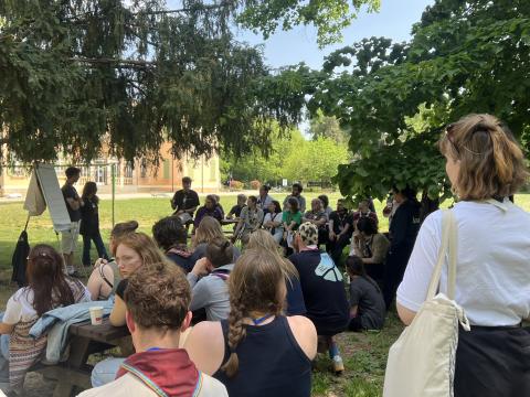 Young people sit outdoors during one of the sessions of the Agora 2026.
