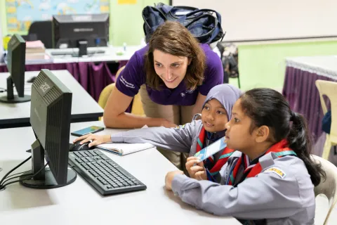 a WOSM staff looking at the computer with other two scouts during Jota joti