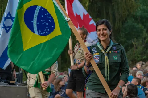 Thaís Querioz, Youth Representative for World Scouting, holds the Brazilian flag during a Scout event.