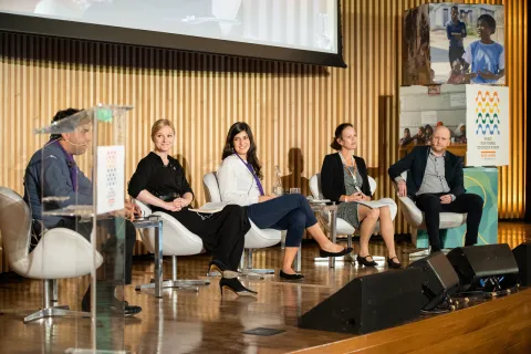 Five panelists sit on stage for a discussion about non-formal education during the Forum in Brazil.