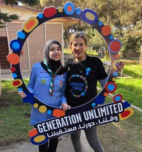 Nour Mahmoudi (left) poses with Generation Unlimited sign