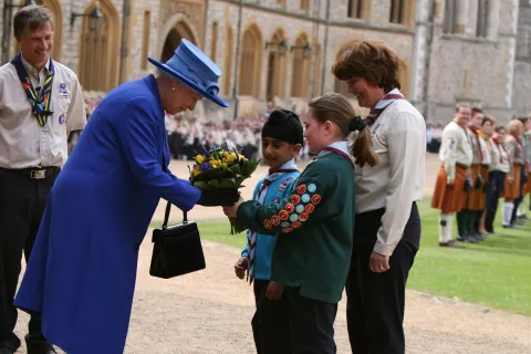 La reine Elizabeth reçoit un bouquet de fleurs de jeunes Scouts