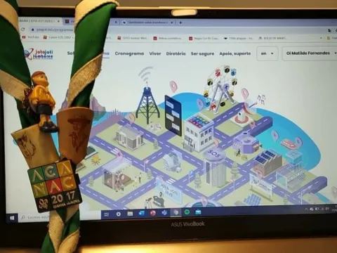 A Scout scarf hangs on a Scout's laptop with the JOTA-JOTI digital campsite on display