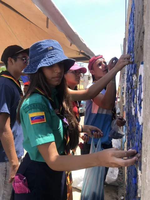 Around 50 volunteers, including Daniela, helped cement 27,500 bottle caps to the wall to create this mural.