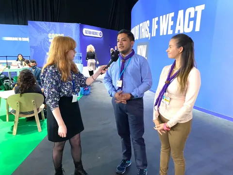 Scouts Grecia and Kazi speak with a reporter during COP26