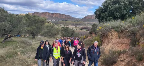 People from Autol, Spain, walk together in solidarity for peace in Ukraine, on trails surrounded by trees and cliffs