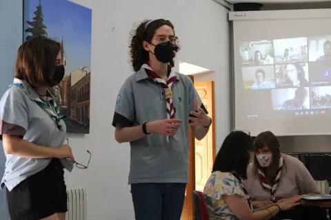 Enci presents in front of other Scouts.