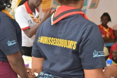 Ugandan Scout wearing a t-shirt that in yellow color reads: No Missed School Days.