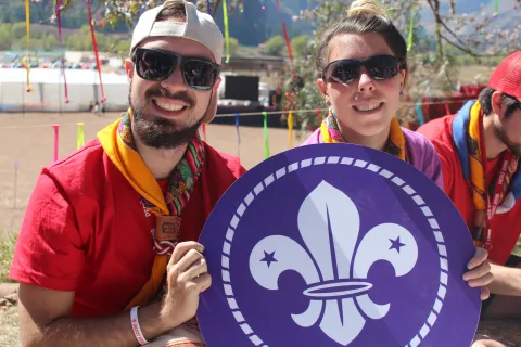 Man and woman holding World Scout emblem