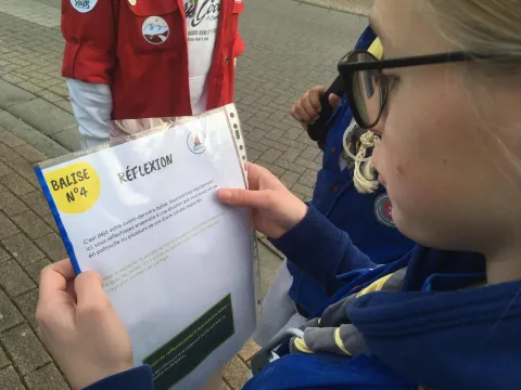 A Scout reads a paper that guides the activity on Human Rights.