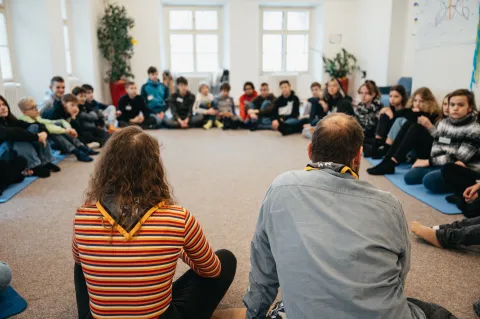 A group of people sitting in a circle on the floor.