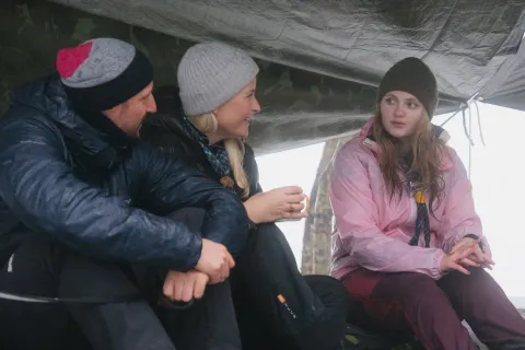 A girl wearing a Scout scarf talks to Crown Prince Haakon and Crown Princess Mette-Marit.