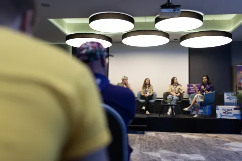 Three people discuss on a stage.