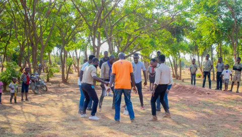 Un groupe d'adolescents en cercle réalise une activité lors d'un événement scout pour les réfugiés au Malawi.