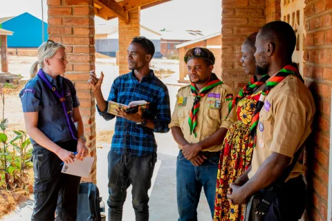 Les Scouts d'un camp de réfugiés au Malawi discutent avec une membre du personnel du Scoutisme Mondial.