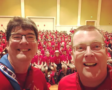 Steve Kent from Canada stands with a group of Canadian volunteers behind him during the World Scout Jamboree in West Virginia, USA