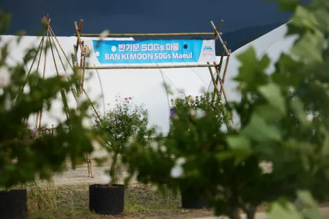 The Ban Ki-moon SDG Maeul sign seen through foliage at the World Scout Jamboree