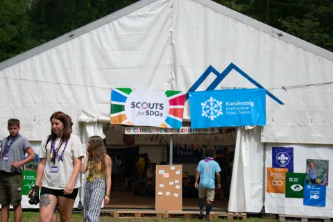 A white pavilion with two signs reading 'Scouts for SDGs' and 'Kandersteg International Scout Centre'.