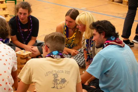 A group of young Scouts sit in a circle and talk.