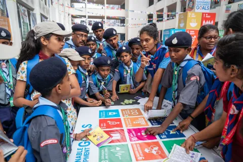 Indian Scouts gather around a banner of the Sustainable Development Goals (SDGs) learning how they can make a difference in the world