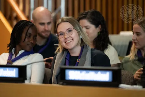 Urtė Petrulytė, WOSM Youth Representative, smiles for the camera while seated in the United Nations General Assembly to represent the interests of young people