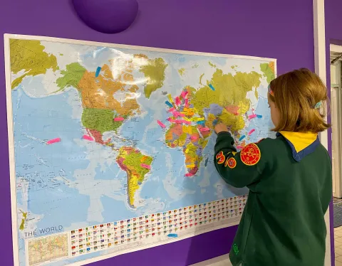 A British Squirrel scout puts a pin on a map during JOTA-JOTI 2023