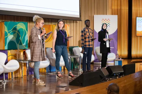 Four Scouts speak on stage during the World Non-Formal Education Forum