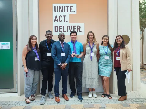 Scouts Kek and Laura pose with other panelists at a COP28 side event about "Fostering Youth-led Entrepreneurship and Innovation for Climate-resilient Communities”