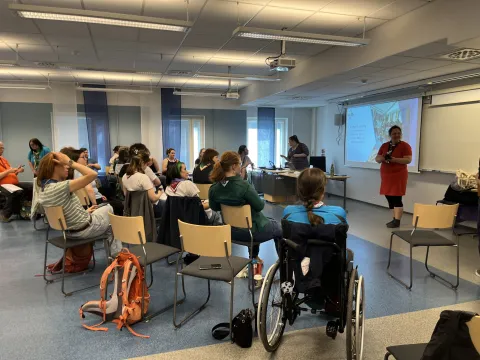 A group of people listen to a presentation.