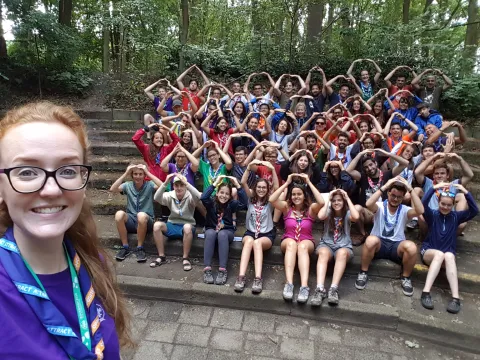 Máire takes a selfie with a group of Scouts seating in the back.