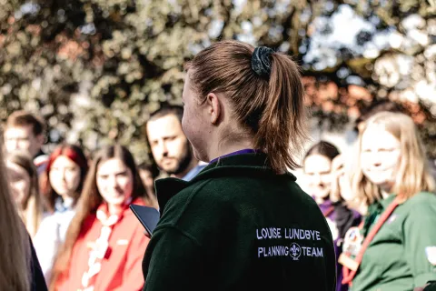 Louise wearing the green sweater of the planning team of the Agora 2023.