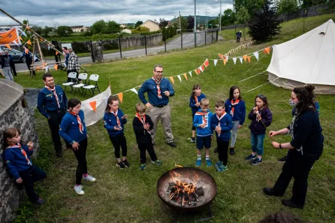 Jil speaks with Scouts around a campfire.