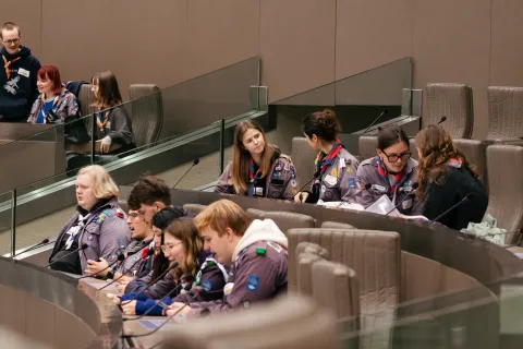 Scout leaders talk while sitting at the Flemish Parliament.