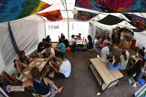 The inside of a tent with young people sitting around tables.