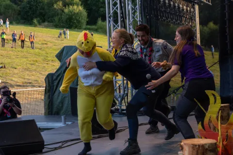 The four contestants try to catch someone dressed up like a chicken.